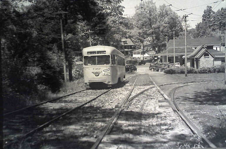 The Catonsville Junction was the terminus for the Baltimore Traction Company's streetcar lines 8, 9, and 14. On this 1950s summer day, a light grey over pencil-yellow Pullman-built PCC (Presidential Car Commission) streetcar departs southbound on the private, quarter mile right-of-way that emptied onto Frederick Road and continued eastward into the city of Baltimore. The little Belgian block gabled structure on the right is still there today, as are the houses in the center rear. The Amoco structure has been replaced by a modern Seven-Eleven convenience store.